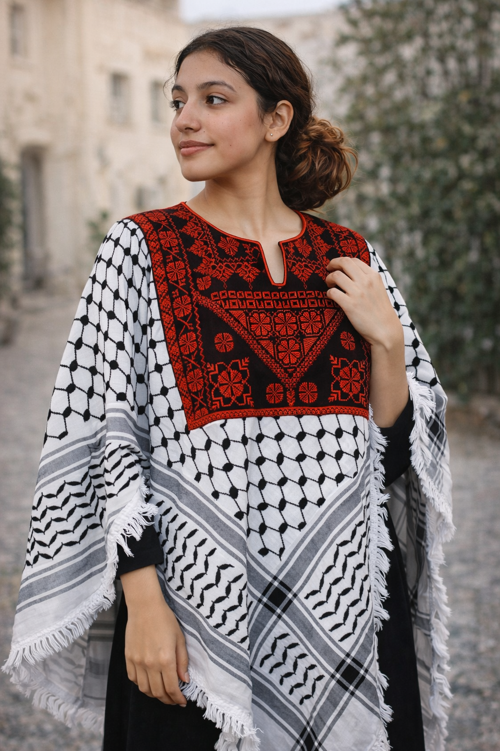 Femme portant un châle brodé Levami à motifs traditionnels colorés dans un jardin.
